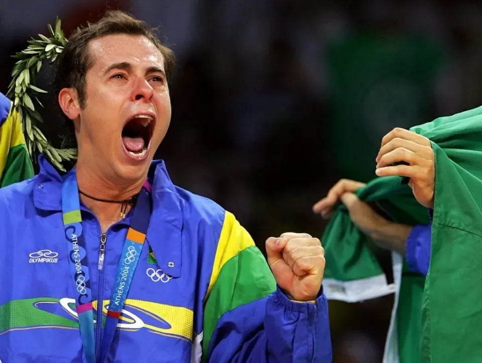 Ricardinho celebra o ouro olímpico em Atenas 2004 com a bandeira do Brasil